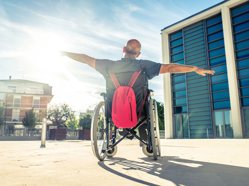 person holding arms out sitting in wheelchair